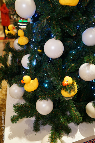 Christmas decorations on the Christmas tree. Duck bath and white balls.