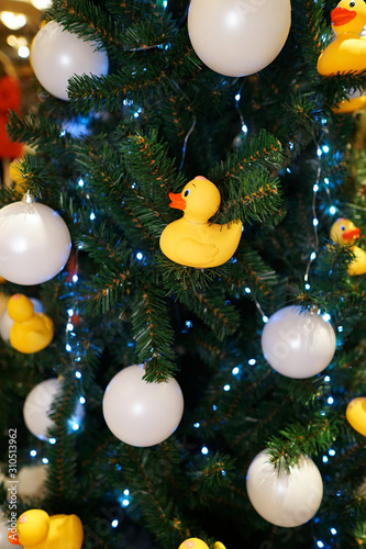 Christmas decorations on the Christmas tree. Duck bath and white balls.