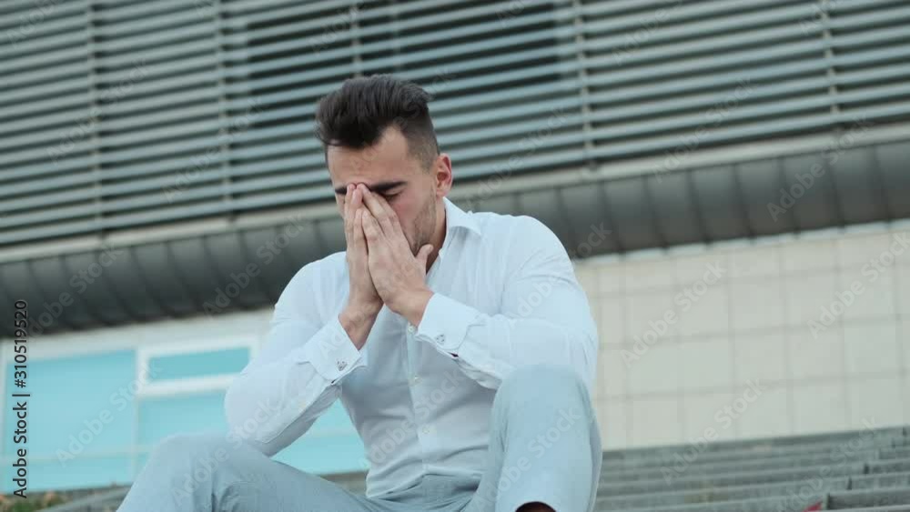 Young Man Sitting On The Stairs Of The Building. Young Man Sitting On The Stairs Of The Building.