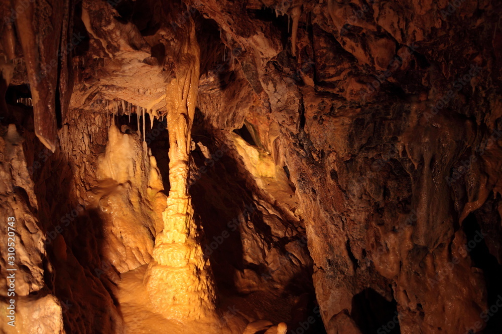 Caving and exploring amazing underground caves with beautiful geological rock formations of speleothems, stalactites and stalagmites Caving and exploring amazing underground caves with beautiful geological rock formations of speleothems, stalactites and stalagmites