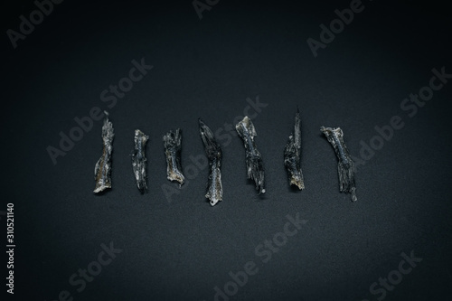 Dried fish tails on dark background close up