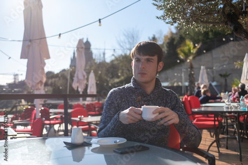 man drinking coffee in a hotel terrace