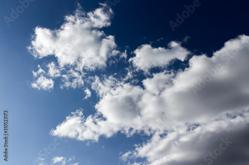 Dark evening sky with white clouds. Twilight blue sky with puffy cumulus clouds  heavenly landscape. Background wallpaper backdrop texture. dark blue dramatic evening sky