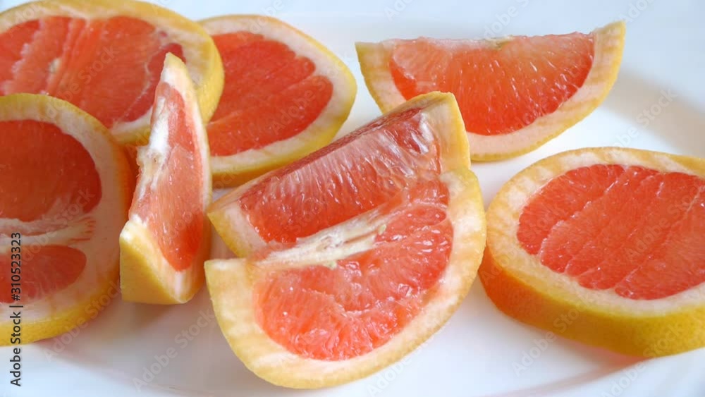 Panorama View Of The Bright Grapefruit Slices On A White Plate Closeup. Panorama View Of The Bright Grapefruit Slices On A White Plate Closeup.