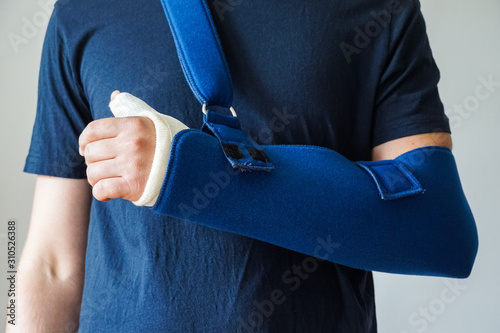 Man with plaster cast on broken thumb,broken wrist, broken hand on arm sling photo