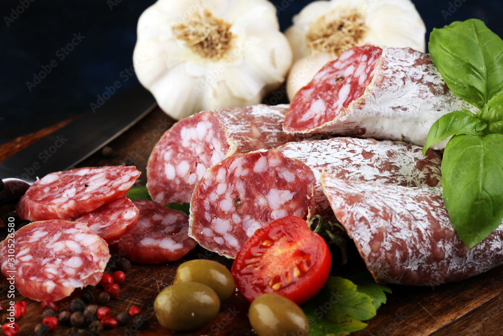 thinly sliced salami on a wooden texture on the background. thinly sliced salami on a wooden texture on the background.