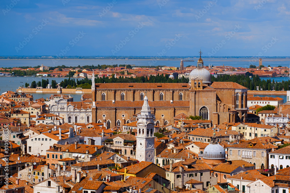 Aerial view of Venice, Italy. Top view of Venice from the Campanile tower of Saint Mark's Cathedral (Basilica di San Marco) and Doges' Palace. Cityscape panorama of Italian houses with red roofs.
