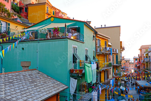 Manarola, Italy. Colorful traditional houses on a rock over Mediterranean sea on sunset, Cinque Terre, Liguria. Colors of amazing little Italian village Riomaggiore.