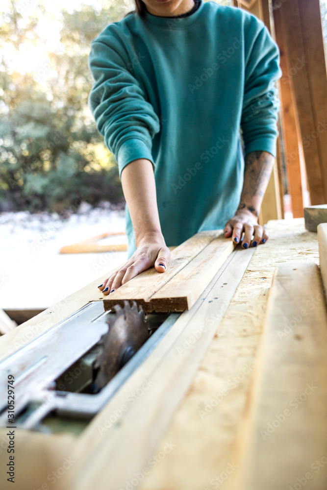 A woman works in a carpentry workshop. A woman works in a carpentry workshop.
