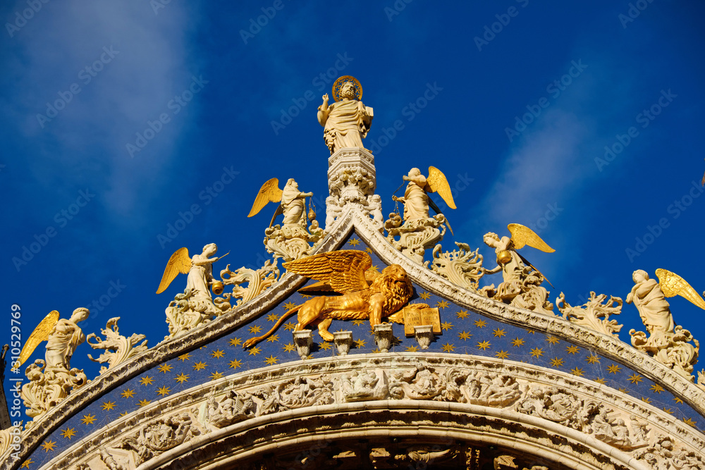 Fototapeta premium Basilica di San Marco under blue sky, Venice, Italy. Saint Mark Basilica and Doge's Palace. Cathedral of San Marco. Roof architecture details with lion, symbol of the City of Venice.