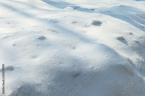 Snow texture of detailed sunny closeup background. Bright new fresh sparkling snowdrift with shadows.