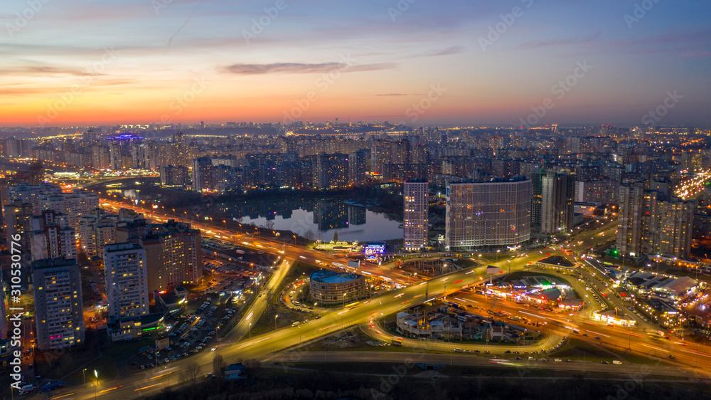 Fototapeta premium Aerial view at junctions of city highway. Vehicles drive on roads.Thailand.Circular road at night Have smooth traffic Light in the night from air.