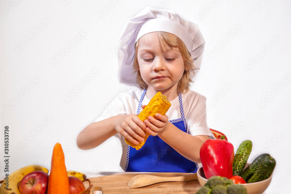 The little chef-cook is sitting at the table with vegetables. isolated on white. The little chef-cook is sitting at the table with vegetables. isolated on white.