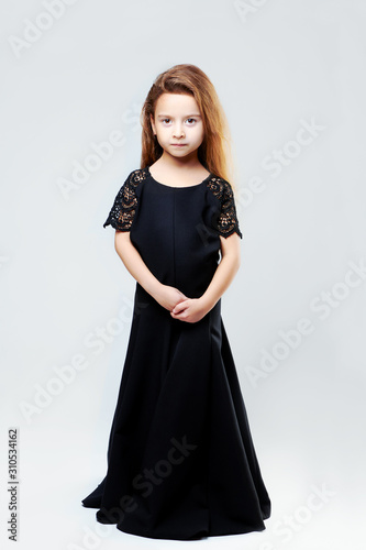 The little girl in an adult dress is shot close-up