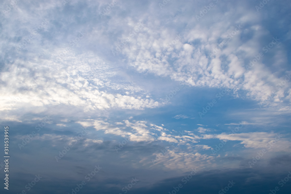 White cirrus clouds sprawled across the sky in front of a dark thunderous front White cirrus clouds sprawled across the sky in front of a dark thunderous front