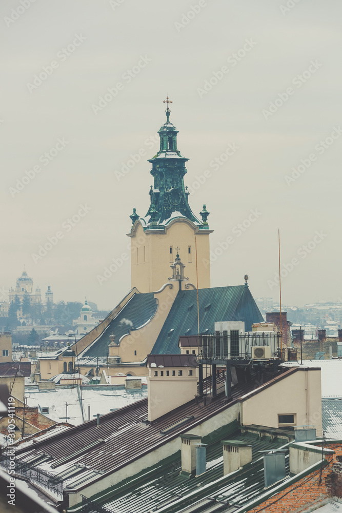 Aerial view of the Archcathedral Basilica of the Assumption of the Blessed Virgin Mary in Lviv, Ukraine. Winter cityscape. The view of the belltower and roofs in snow