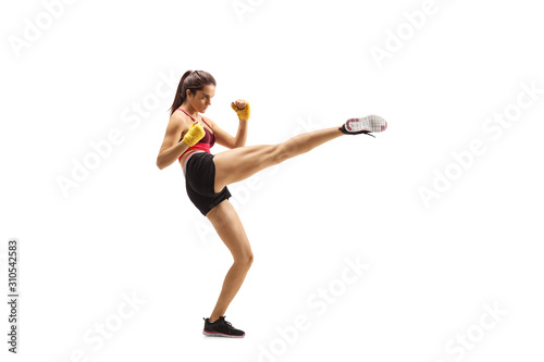 Young fit woman kicking with a leg