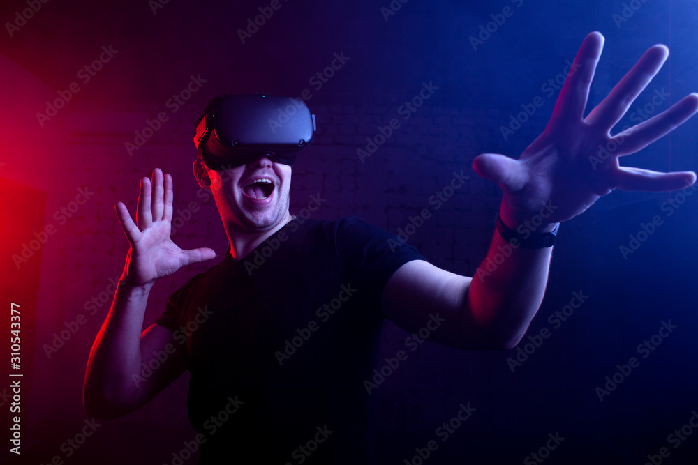 scared guy a gamer in a virtual reality game room, a man screams in VR glasses and plays a shooter scared guy a gamer in a virtual reality game room, a man screams in VR glasses and plays a shooter