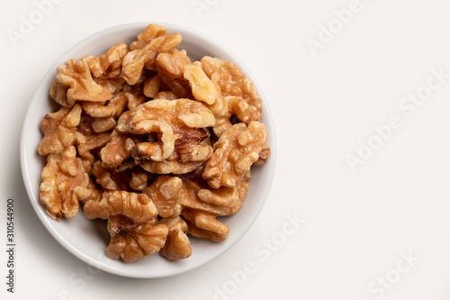 walnuts in a bowl isolated on white close up 