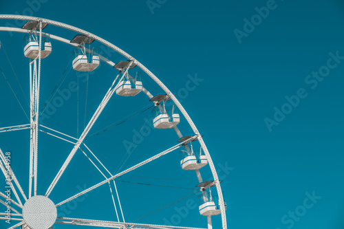 Half shot of a ferris wheel in a blue sky