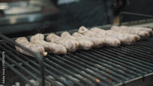 Hot food on Christmas fair. As tradions sausages cooking on open fire. Bbq Sausages In The Market. Christmas market food. Sausages on the grill. The process of cooking meat sausages on the grill photo