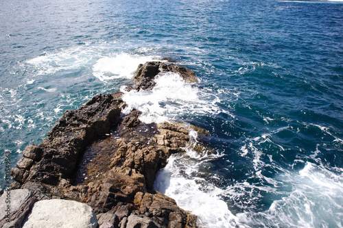 The water of the sea crashes against the rocks of the coast