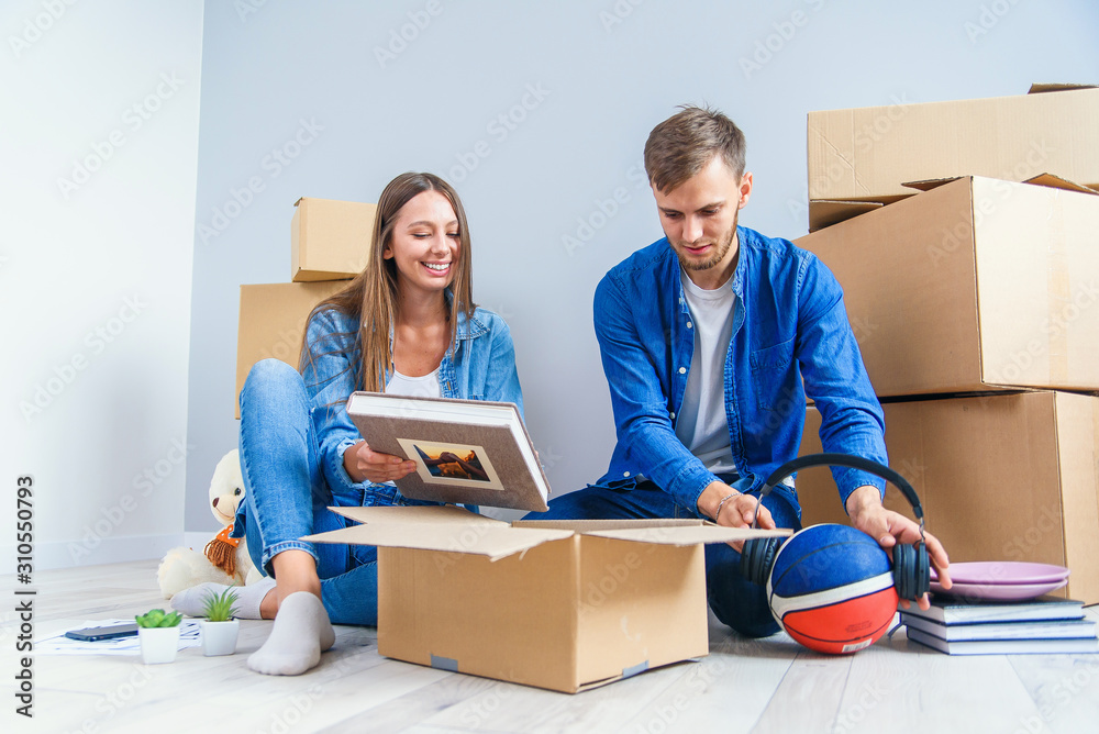 Young couple unpacking things after moving into new house Young couple unpacking things after moving into new house