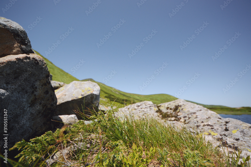 Beautiful mountain landscape, with mountain peaks covered with forest and cloudy sky.Ukrainian Carpathian Mountains.Big rocks near lake. Beautiful mountain landscape, with mountain peaks covered with forest and cloudy sky.Ukrainian Carpathian Mountains.Big rocks near lake.