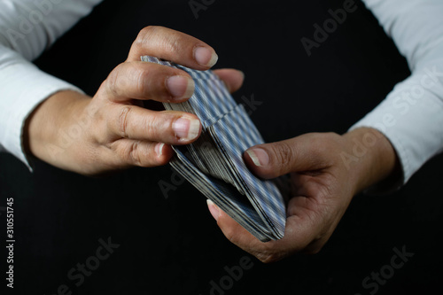 Tarot cards in hands and black background