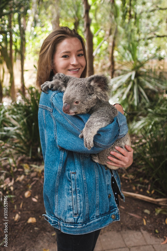 Magnetic island, Australia: Young happy woman holding koala and smiling	