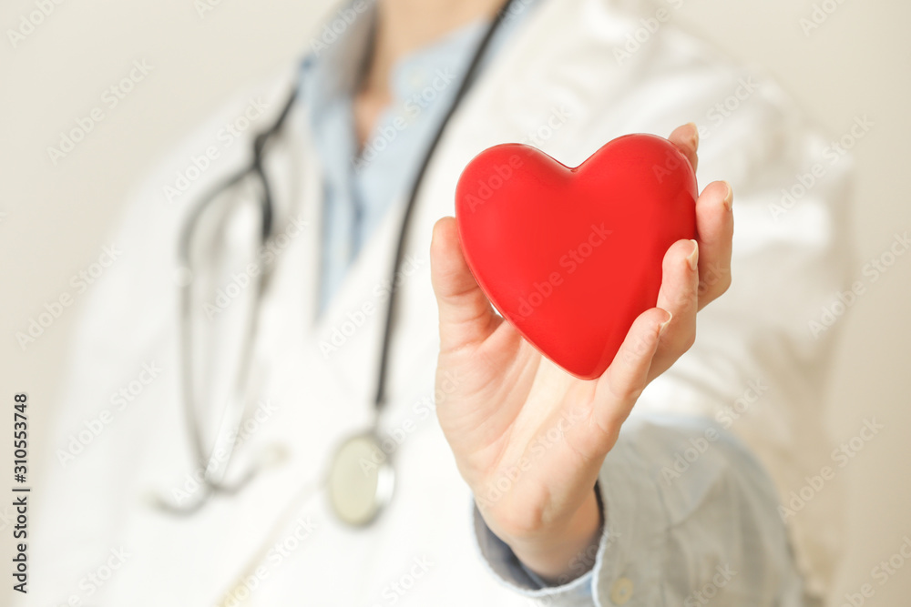 Medical worker holding a red heart as a symbol of health, health care concept Medical worker holding a red heart as a symbol of health, health care concept