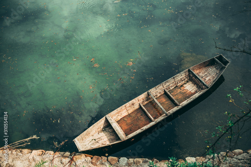 Small old wooden boat on the riverbank