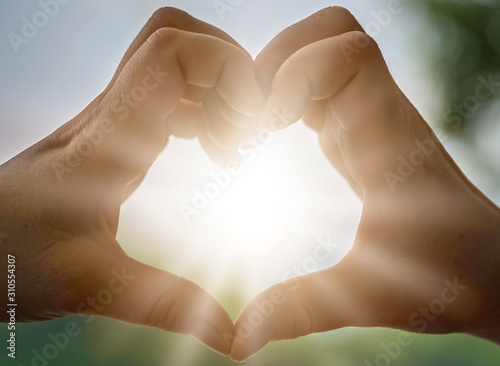 Womans hands catching sunlight at dusk