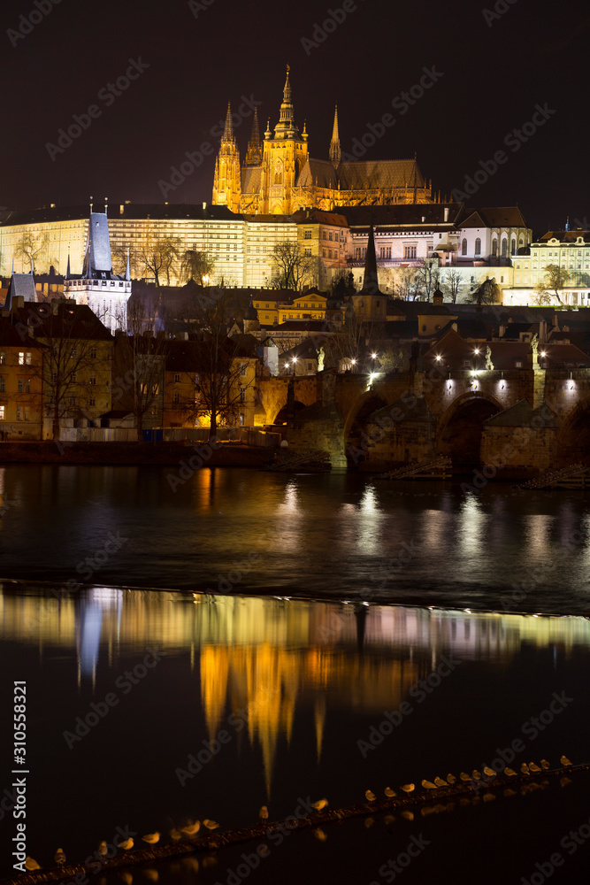 Night winter Prague Lesser Town with the gothic Castle and Charles Bridge above the River Vltava, Czech Republic