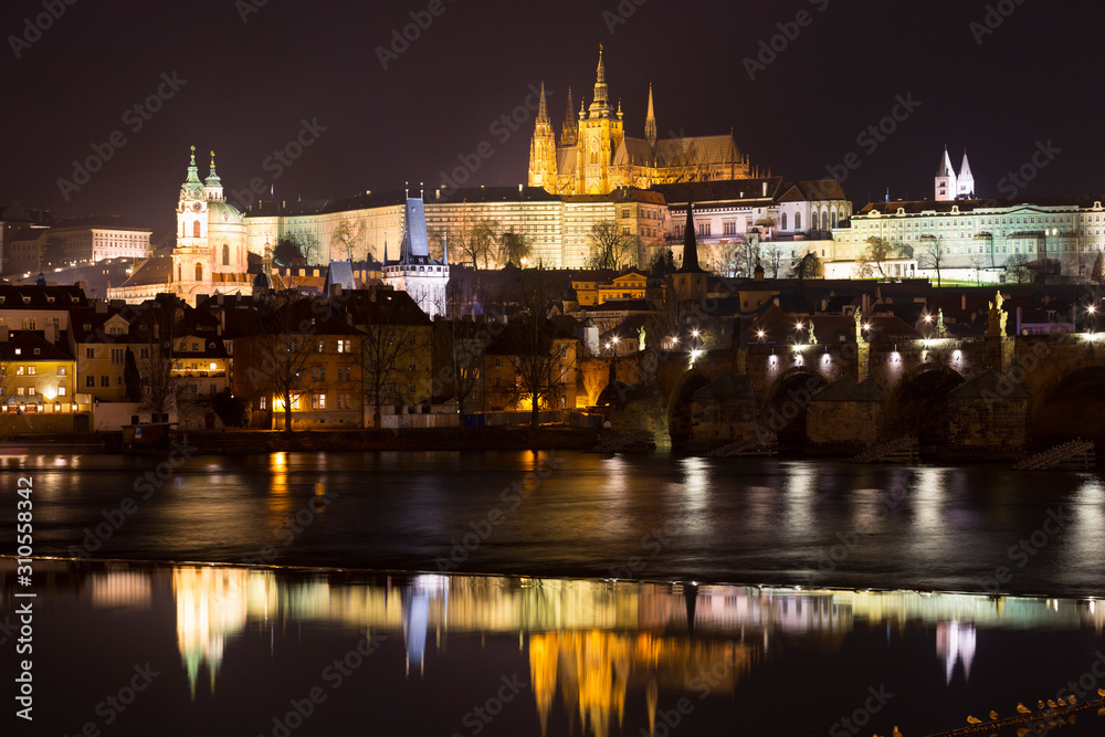 Night winter Prague Lesser Town with the gothic Castle and Charles Bridge above the River Vltava, Czech Republic