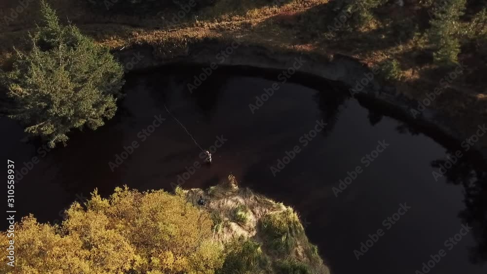 Fly fisherman casting in a river, drone Fly fisherman casting in a river, drone