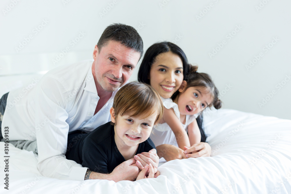 family happy and relaxing in bedroom. mother and father playing with a children..