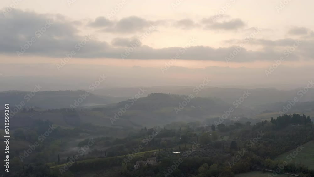 Italy. Tuscany. Early Sunny morning. Thick fog over fields, farmhouses and vineyards Italy. Tuscany. Early Sunny morning. Thick fog over fields, farmhouses and vineyards