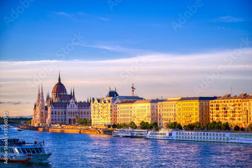 The Hungarian Parliament Building located on the Danube River in Budapest Hungary at sunset.