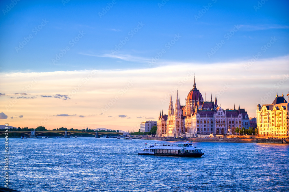 The Hungarian Parliament Building located on the Danube River in Budapest Hungary at sunset.