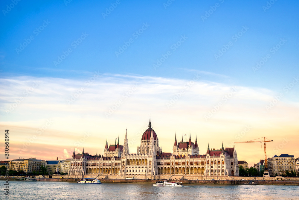 The Hungarian Parliament Building located on the Danube River in Budapest Hungary at sunset.