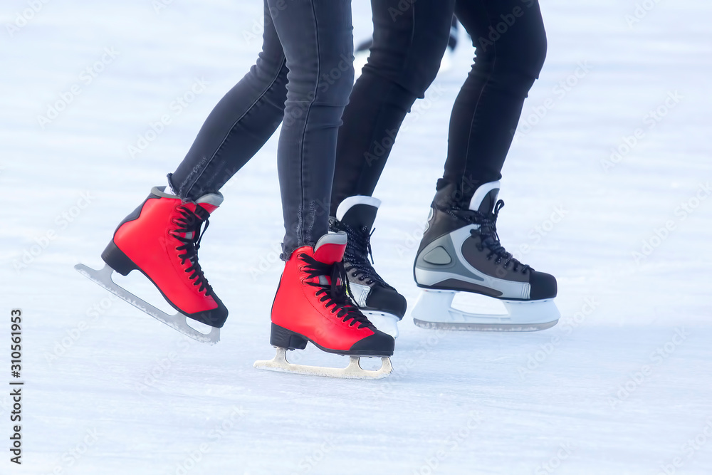 different people are actively skating on an ice rink different people are actively skating on an ice rink