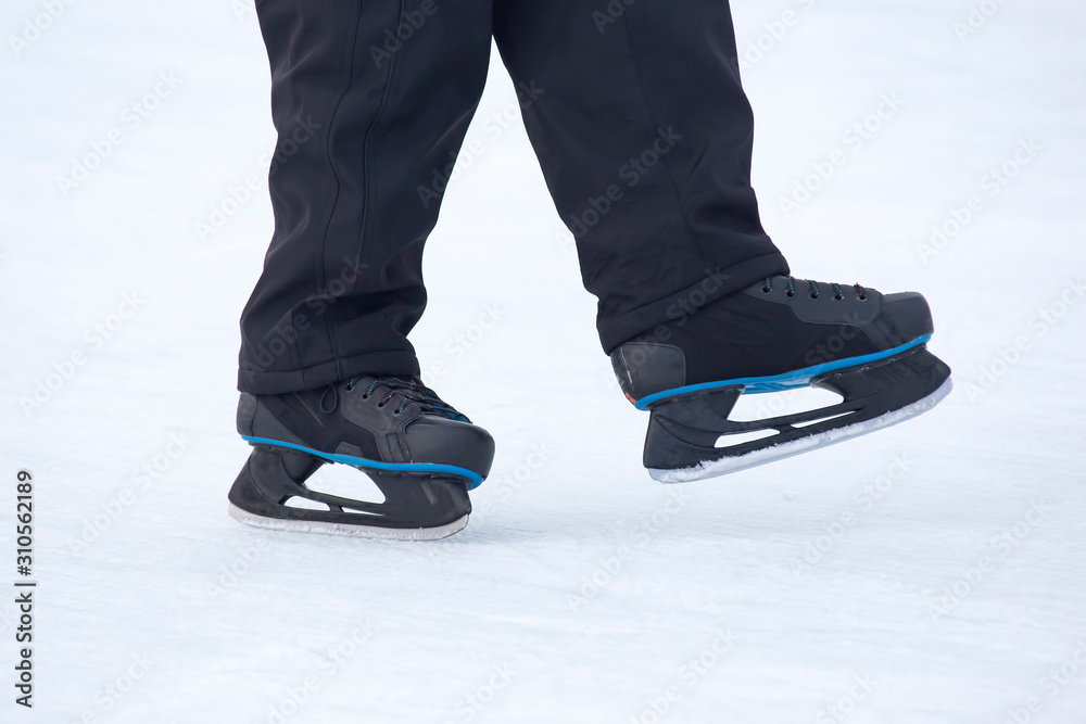 legs of a skating man on an ice rink. Hobbies and sports. Vacations and winter activities. legs of a skating man on an ice rink. Hobbies and sports. Vacations and winter activities.
