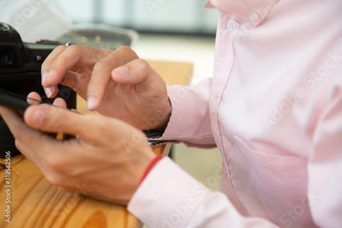 businessman hands searching for data on mobile phone with analyzing charts at his workplace.