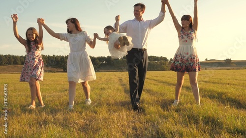 concept of a happy family. Children and mom are playing in meadow. mother and little daughter with sisters walking in park. Happy young family with child walking on summer field. happy family concept