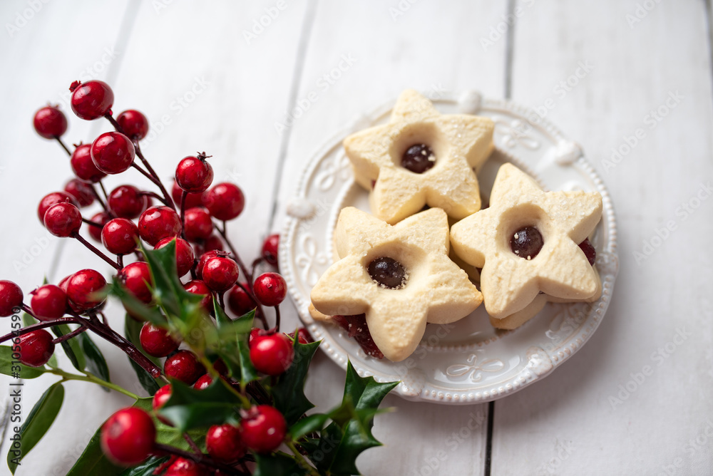 Christmas shortbread star cookies with strawberry jam. Festive atmosphere holiday pastry baking concept.