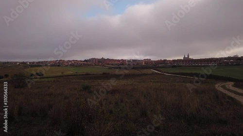 A motion lapse of a small town, moving towards right, to a dirt road thah ends in the town photo