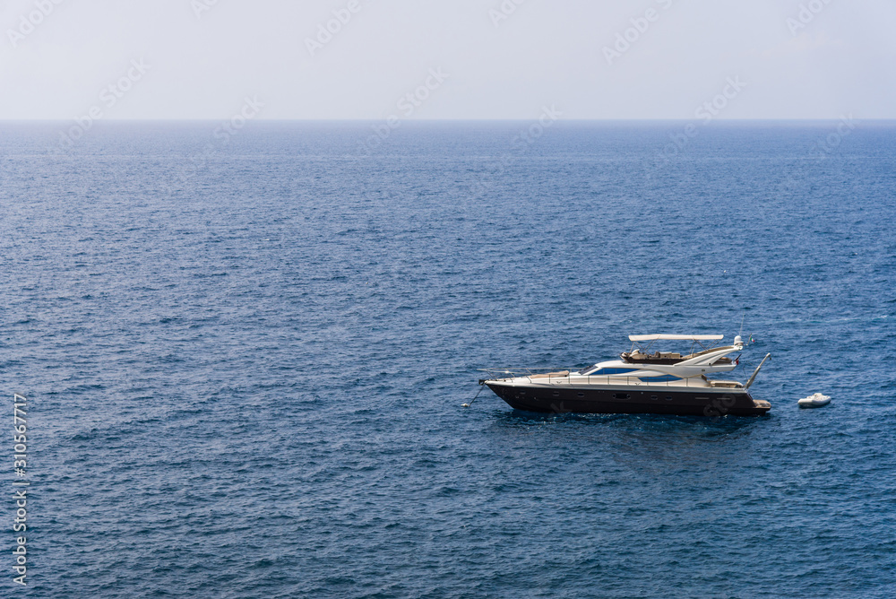 View at a yacht at Ligurian Sea coastline in Liguria, Italy, with aquamarine transparent water View at a yacht at Ligurian Sea coastline in Liguria, Italy, with aquamarine transparent water