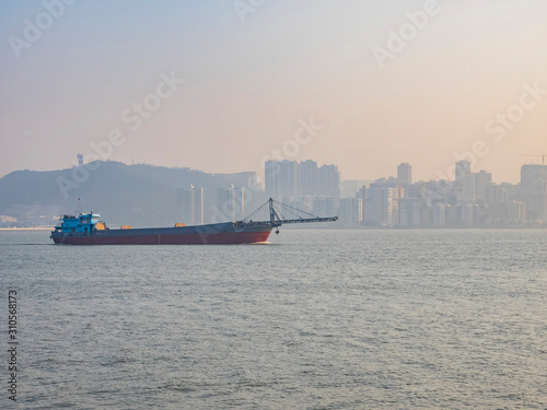 Afternoon view of a cargo ship and Taipa cityscape