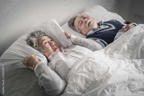 elderly couple caucasian senior woman and man sleep on bed and snoring in white blanket in bedroom, retirement health care with love lifestyle concept